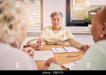 Senioren, Gruppengebet und Hände am Tisch halten, unterstützen und verehren den Heiligen Geist, Jesus Christus und Gott. Ältere Freunde, Religion und Stockfoto