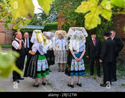 Burg, Deutschland. August 2023. Mitglieder der Heimat und Trachtenverein in Burg im Spreewald warten in sorbisch-wenischen Kostümen auf den Beginn des Gottesdienstes. Am Nachmittag findet die große Parade zum 29. Heimat- und Trachtenfest im Spreewald statt. Quelle: Patrick Pleul/dpa/Alamy Live News Stockfoto