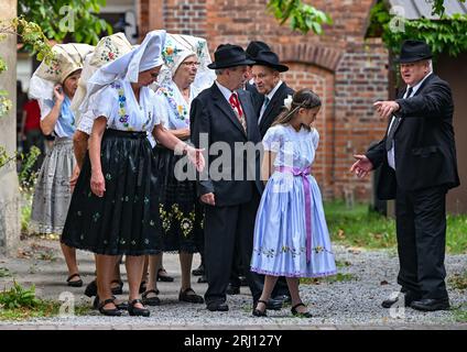 Burg, Deutschland. August 2023. Mitglieder der Heimat und Trachtenverein in Burg im Spreewald warten in sorbisch-wenischen Kostümen auf den Beginn des Gottesdienstes. Am Nachmittag findet die große Parade zum 29. Heimat- und Trachtenfest im Spreewald statt. Quelle: Patrick Pleul/dpa/Alamy Live News Stockfoto