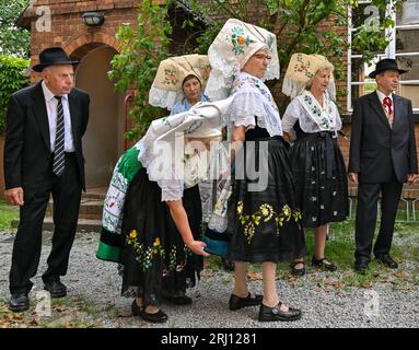 Burg, Deutschland. August 2023. Mitglieder der Heimat und Trachtenverein in Burg im Spreewald warten in sorbisch-wenischen Kostümen auf den Beginn des Gottesdienstes. Am Nachmittag findet die große Parade zum 29. Heimat- und Trachtenfest im Spreewald statt. Quelle: Patrick Pleul/dpa/Alamy Live News Stockfoto