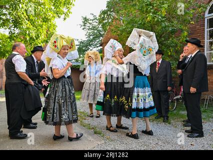 Burg, Deutschland. August 2023. Mitglieder der Heimat und Trachtenverein in Burg im Spreewald warten in sorbisch-wenischen Kostümen auf den Beginn des Gottesdienstes. Am Nachmittag findet die große Parade zum 29. Heimat- und Trachtenfest im Spreewald statt. Quelle: Patrick Pleul/dpa/Alamy Live News Stockfoto