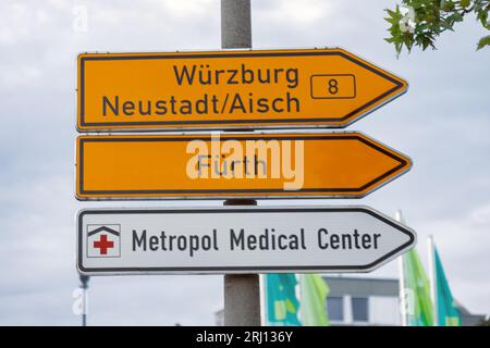 Nürnberg, Deutschland - 18. August 2023: Fürth, Würzburg, Neustadt Aisch Stadtschild - Ortsnamensschild. Und das Metropol Medical Center Nürnberg. Stockfoto