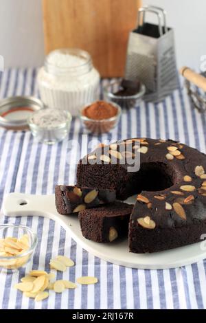 Brownie Cake Ketan Hitam mit Mandelscheiben. Schwarzer klebriger Reismehlkuchen mit Mandel-Topping, gesunder Kuchen Stockfoto