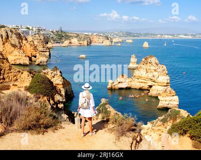 Alleinreisende Frau, Frau genießt die Aussicht Camilo Beach Camilo Beach, Praia do Camilo, Natural Cliff Formation und Beach Cove Lagos, Algarve, Portugiesisch Stockfoto