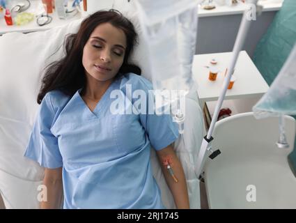 Schönes Mädchen schläft in der Klinik unter Drogendropfer Stockfoto