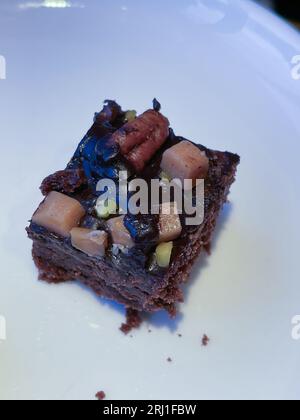 Flache Lay-Komposition mit frischen Brownies auf Pergamentpapier. Köstlicher Schokoladenkuchen Stockfoto