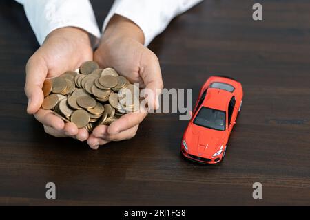 Geschenk für ein neues Auto. Hintergrund Autohaus und Mietkonzept. Spargeld für Fahrzeugkonzept, Handelsfahrzeug für Bargeld, Finanzierungskonzept. Stockfoto