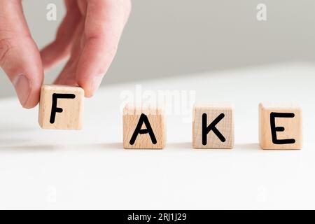 Das Wort 'Fake', mit hölzernen Buchstabensteine geschrieben, Stockfoto