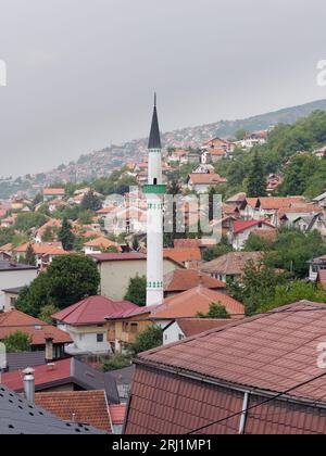 Hügelhäuser und Minarett in Sarajevo, Bosnien und Herzegowina, 19. August 2023. Stockfoto