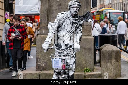 Edinburgh, Schottland, Großbritannien, 20. August 2023. Straßenkünstler in Fringe: Eine lebendige bemalte Statue auf der Royal Mile mit einem Fahrrad. Sally Anderson/Alamy Live News Stockfoto