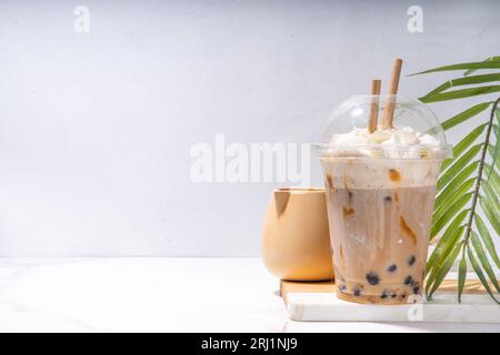 Tapioca boba Balls Coffee Frappe, asiatisch-trendiges kaltes Kaffeegetränk mit Tapiokasseln und Kokosnuss-Schlagsahne und Karamellsauce Stockfoto