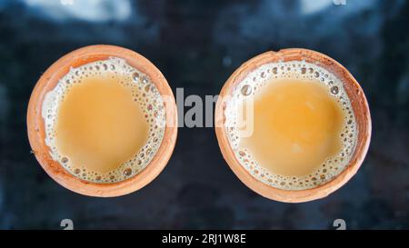 Kulhad Chai ist ein Teegetränk aus Indien, Milchtee mit aromatischen Kräutern und Gewürzen, Tasse Tee auf schwarzem Hintergrund Stockfoto