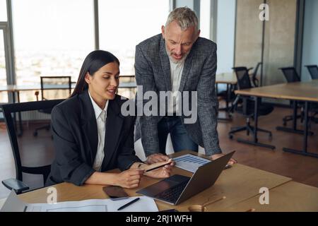 Zwei Kollegen besprechen das Projekt, bevor sie dem Teamleiter im Büro eine Präsentation zeigen Stockfoto