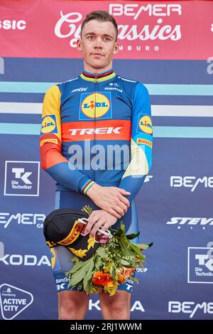 Hamburg, Deutschland. August 2023. Radfahren: UCI WorldTour - Cyclassics, Herren. Der Erstplatzierte Mads Pedersen aus Dänemark vom Team Lidl-Trek steht während der Preisverleihung auf dem Podium. Quelle: Georg Wendt/dpa/Alamy Live News Stockfoto