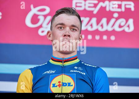 Hamburg, Deutschland. August 2023. Radfahren: UCI WorldTour - Cyclassics, Herren. Der Erstplatzierte Mads Pedersen aus Dänemark vom Team Lidl-Trek steht während der Preisverleihung auf dem Podium. Quelle: Georg Wendt/dpa/Alamy Live News Stockfoto