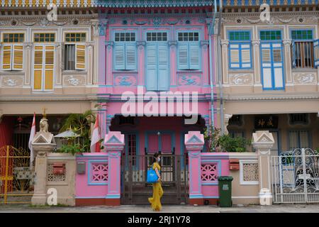 Junge Frau in gelbem Kleid geht an restaurierten Peranakan-Häusern im angesagten Stadtteil Joo Chiat in Singapur vorbei. 21/08/2022 Stockfoto