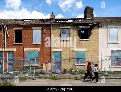 BRADFORD, GROSSBRITANNIEN – 16. AUGUST 2023. Eine Reihe von ausgebrannten und verfallenen Terrassenhäusern in einer armen asiatischen Gemeinde im Norden Englands mit aufgehängtem Wind Stockfoto