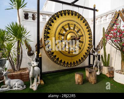 Auf dem Goldenen Berg des Wat Saket in Bangkok, Thailand, steht eine goldene buddhistische Dong-Glocke, die als Tempelglocke oder Mokugyo anerkannt ist, begleitet von Hirschstämmen Stockfoto