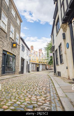 Alte Häuser und Geschäfte entlang der engen Kopfsteinpflasterstraße von Elm Hill in Norwich, die im August 2023 zu sehen waren. Stockfoto