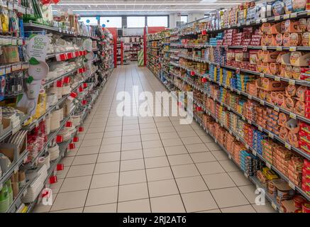 Italien - 20. August 2023: Italienischer Supermarktgang mit Thunfisch- und Fisch- sowie Fleischdosen und Papiergeschirr in den Regalen zum Verkauf Stockfoto