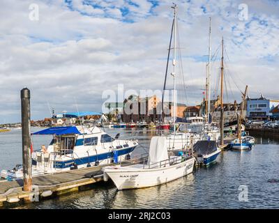 An einem Abend im August 2023 füllen die Boote den Rahmen im Hafen von Wells an der Nordküste Norfolks. Stockfoto