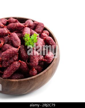 Mini-Salami-Würstchen in Holzschale isoliert auf weiß Stockfoto