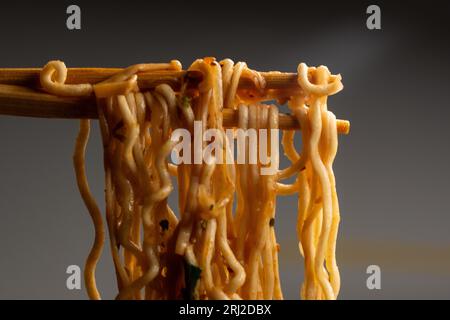Nahaufnahme von Ramen-Nudeln mit Essstäbchen, die in sie getaucht und gegessen wurden Stockfoto