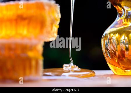 Schatz. Natürlicher Honig und Honigwabe. Süßer Honigguss. Nahaufnahme von köstlichen Bienenwaben auf einem Holzschneidebrett. Stockfoto