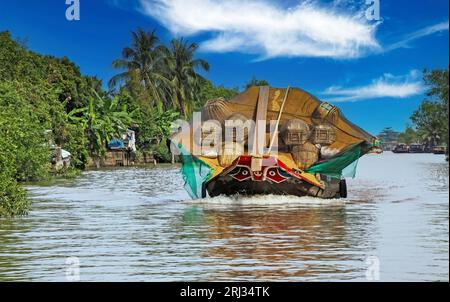 Wunderschöne Mekong Delta Landschaft, ein traditionelles typisch vietnamesisches Sampan Reis Frachtboot, grüne Palmen - Mekong Delta, Vietnam Stockfoto