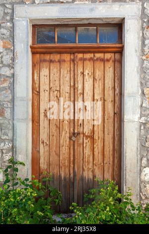 Schöne alte, traditionelle Holztür, mit Nachtkernen an der Schwelle, im malerischen Dorf Fourni, in der Region Lasithi, Kreta Insel. Stockfoto