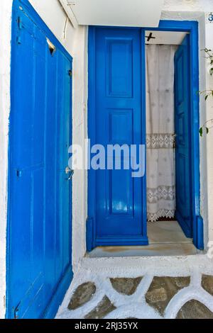 Eingang eines traditionellen Hauses mit typisch kykladischer Architektur mit blauen Türen und weißen Wänden, auf der Insel Mykonos, Kykladen, Griechenland, Europa. Stockfoto