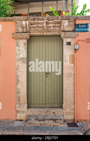 Wunderschöne Holztür in einem alten, traditionellen Herrenhaus mit Steinsturz, in der Altstadt von Ägina, auf der Insel Ägina, Griechenland, Europa. Stockfoto