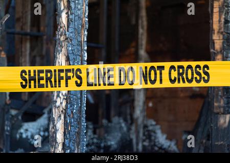 Das Haus wurde von einem Pyromaniac mit einem Polizeiband mit der Aufschrift „Sheriff's Line Don't Cross“ niedergebrannt. Stockfoto