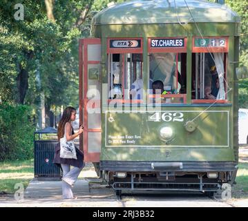 NEW ORLEANS, LA, USA - 18. AUGUST 2023: Woman Boarding Historic St. Charles Line Straßenbahnlinie an der Ecke von S. Carrollton Avenue und Oak Street Stockfoto