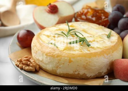 Leckerer gebackener Brie-Käse auf dem Tisch serviert, Nahaufnahme Stockfoto