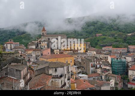 Die Gemeinde Castiglioni di Sicilia in Sizilien, Italien, mit Wohngebäuden, die von üppigen Bäumen und Wolken umgeben sind Stockfoto