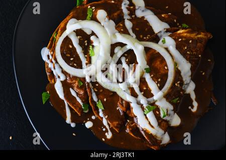 Enmoladas. Mexikanische Küche. Enchiladas mit Hühnchen, gekocht in Mole-Poblano-Sauce. Stockfoto