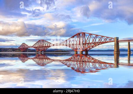 Die Forth Rail Bridge, eines der berühmtesten Wahrzeichen Schottlands, mit einer Reflexion im Firth of Forth. Entworfen von den Ingenieuren Sir John Fowler und... Stockfoto