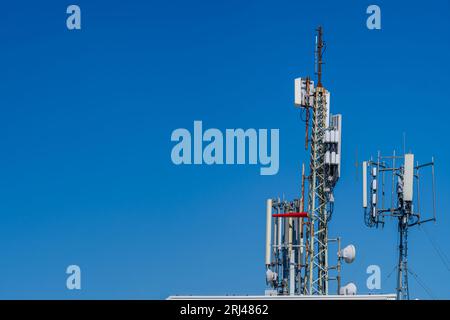Nahaufnahme des Turms mit 6G-, 5G-, 4G-Mobilfunkantenne auf blauem Himmelshintergrund. Stockfoto