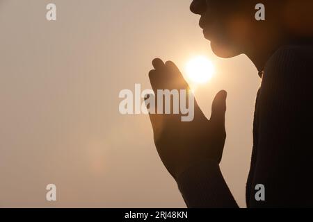 Silhouette der Gebetshaltung der Frau, betende Hände mit Glauben an Religion und Glauben an Gott auf dunklem Hintergrund. Kraft der Hoffnung oder Liebe und Hingabe. Entfällt Stockfoto
