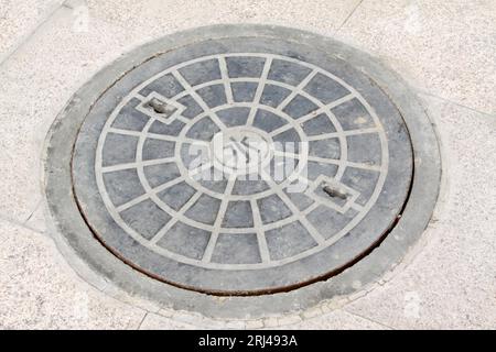 Metallschachtabdeckung in der Straße in China Stockfoto