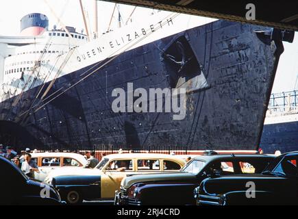 Ein Farbfoto aus den 1950er Jahren, das den RMS Queen Elizabeth Ocean Liner im Dock in New York zeigt. Stockfoto