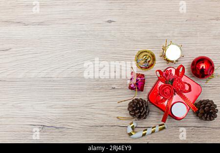 Weihnachtliche Geschenkboxen mit Blick aus dem hohen Winkel auf rustikalem Holzfußboden. Die Geschenke sind an den Rändern des Rahmens verstreut, sodass etwas Platz bleibt Stockfoto