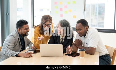 Eine Gruppe glücklicher, vielfältiger Geschäftsleute oder Startups diskutiert gerne gemeinsam über die Arbeit und plant gemeinsam ein neues Projekt im Tagungsraum. Stockfoto