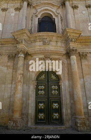 Antikes Portal mit Blick auf die sizilianische Barockkirche Chiesa di San Michele Arcangelo, ein historisches religiöses Denkmal in Scicli Sizilien, Italien. Stockfoto