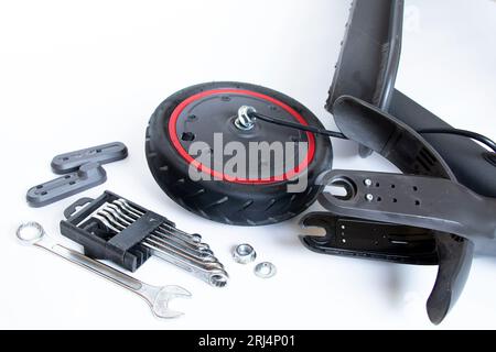 Zerlegter Elektroroller, Reifenpanne und Austausch durch ein neues Rad, Reparatur und Wartung von Elektrotransporten Stockfoto