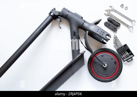Zerlegter Elektroroller, Reifenpanne und Austausch durch ein neues Rad, Reparatur und Wartung von Elektrotransporten Stockfoto