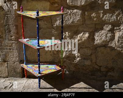 Sizilianisches dreieckiges Holzregal mit handbemaltem Majolica-Motiv in Scicli Sicily, Italien. Stockfoto