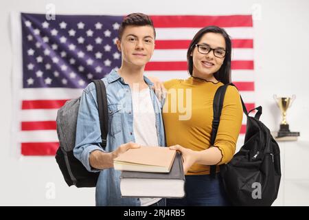 Schüler, die Bücher vor einer Flagge der USA halten Stockfoto