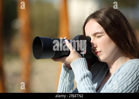 Profil eines Fotografen, der an einem sonnigen Tag Fotos im Freien macht Stockfoto